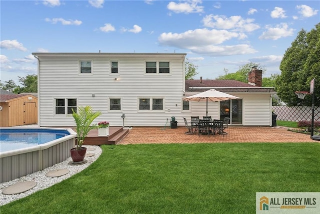 39 Evergreen Ter, Monroe, NJ 08831 - rear view of property with a wooden deck, an outdoor pool, a chimney, a patio area, and a storage shed