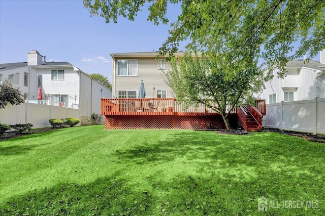 back of property featuring a deck and a yard