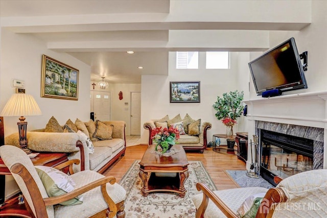 living room featuring a fireplace, light wood-type flooring, and a chandelier