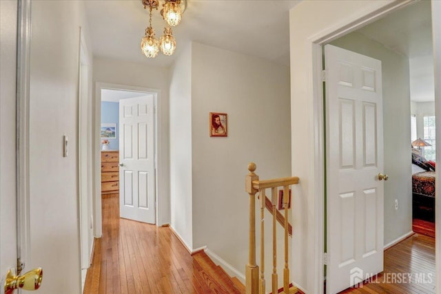 hall featuring a chandelier and light hardwood / wood-style floors