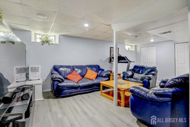 living room with wood-type flooring and a paneled ceiling