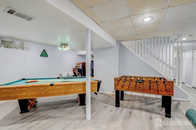 playroom with a drop ceiling and wood-type flooring