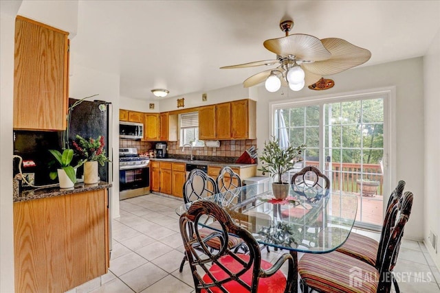 tiled dining area with ceiling fan and sink