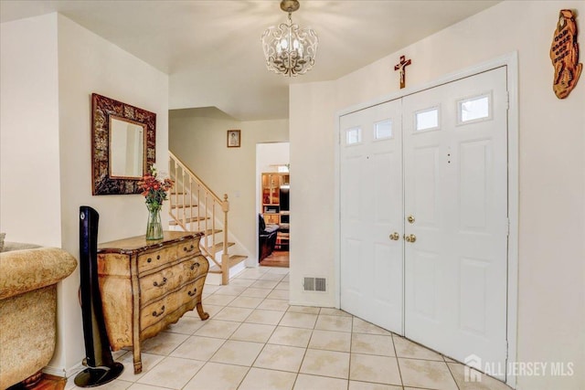 foyer entrance featuring light tile patterned floors and a notable chandelier