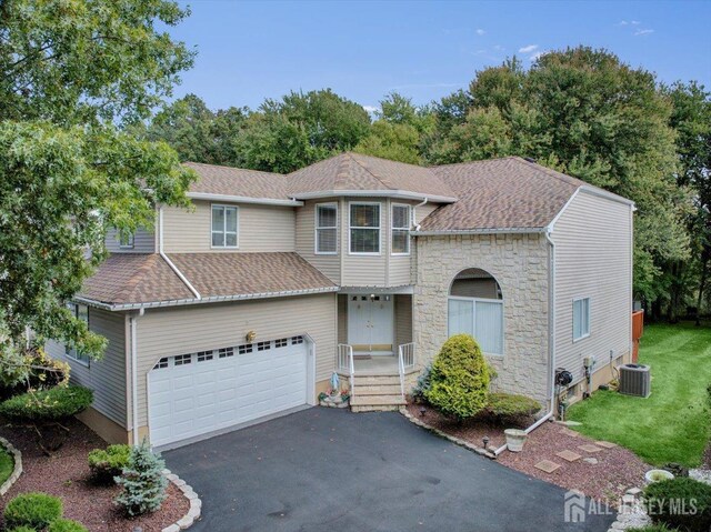 front of property featuring a garage and central AC