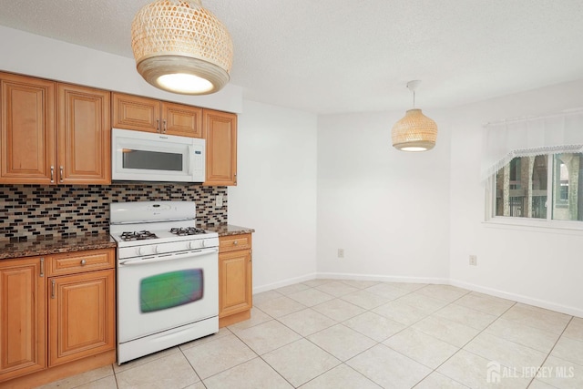 55 Smith St, Perth Amboy, NJ 08861 - kitchen featuring white appliances, tasteful backsplash, dark stone countertops, and light tile patterned flooring