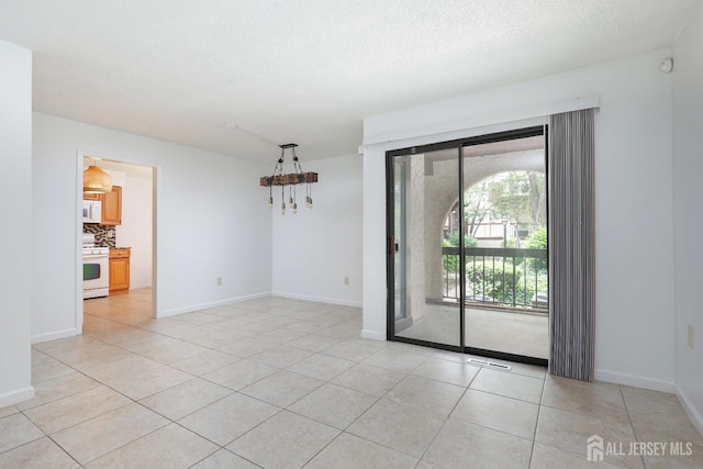 55 Smith St, Perth Amboy, NJ 08861 - empty room with light tile patterned flooring, a chandelier, and a textured ceiling