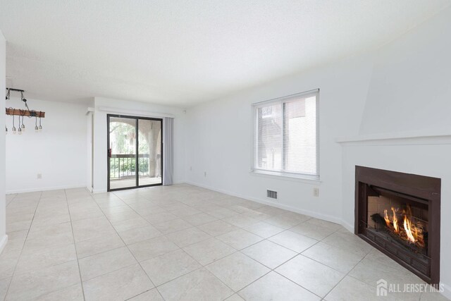 55 Smith St, Perth Amboy, NJ 08861 - unfurnished living room with a warm lit fireplace and light tile patterned floors