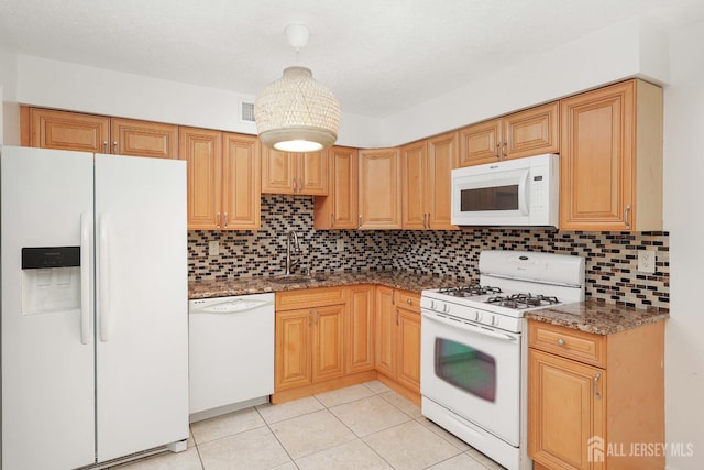 55 Smith St, Perth Amboy, NJ 08861 - kitchen with white appliances, backsplash, dark stone counters, and light tile patterned floors