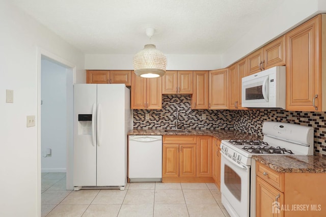 55 Smith St, Perth Amboy, NJ 08861 - kitchen with white appliances, decorative backsplash, light tile patterned flooring, and dark stone counters