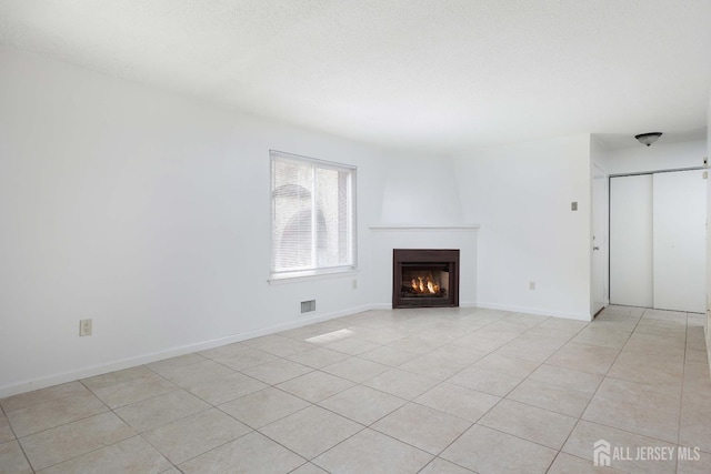 55 Smith St, Perth Amboy, NJ 08861 - unfurnished living room featuring a warm lit fireplace and light tile patterned floors