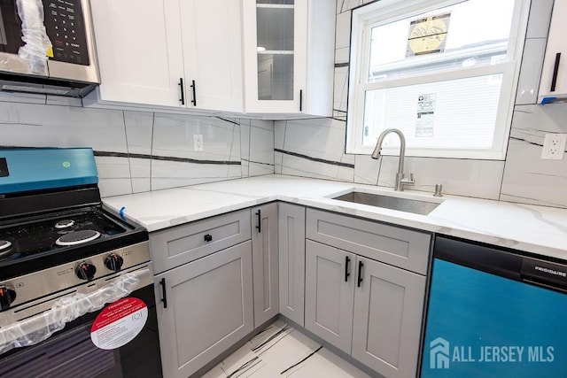 20 Wick Dr, Fords, NJ 08863 - kitchen with stainless steel appliances, gray cabinets, tasteful backsplash, glass insert cabinets, and light stone counters