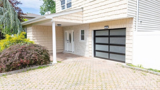20 Wick Dr, Fords, NJ 08863 - property entrance featuring decorative driveway, a garage, and stone siding