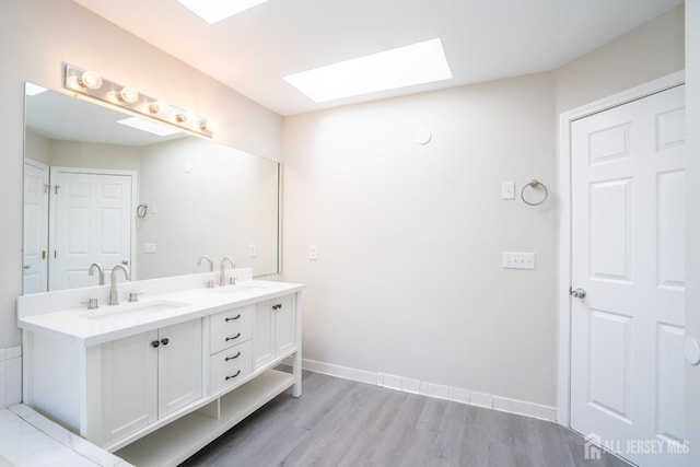 23 Heather Ct, Plainsboro, NJ 08536 - bathroom featuring a skylight, double vanity, wood finished floors, and baseboards
