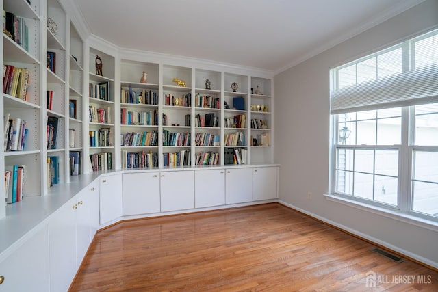 23 Heather Ct, Plainsboro, NJ 08536 - unfurnished room featuring light wood-style floors, ornamental molding, baseboards, and wall of books