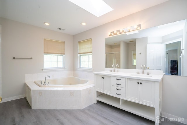23 Heather Ct, Plainsboro, NJ 08536 - full bath featuring a skylight, wood finished floors, a jetted tub, a stall shower, and double vanity