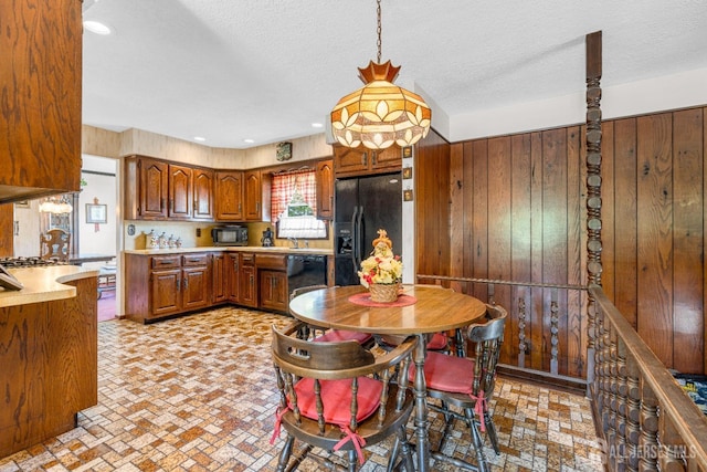 92 Maplewood Ave, Edison, NJ 08837 - kitchen with black appliances, light countertops, brown cabinets, wood walls, and pendant lighting