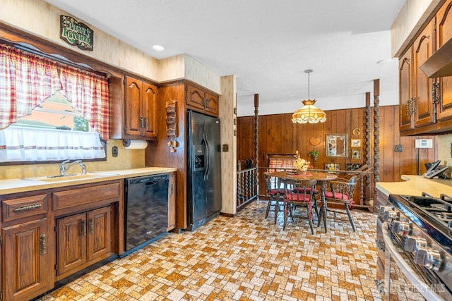 92 Maplewood Ave, Edison, NJ 08837 - kitchen featuring black appliances, wood walls, light countertops, brown cabinetry, and pendant lighting