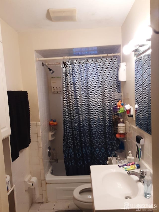 bathroom with toilet, vanity, tile walls, tile patterned floors, and shower / bath combo with shower curtain