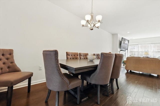 dining area with baseboards, dark wood-style floors, a chandelier, and lofted ceiling