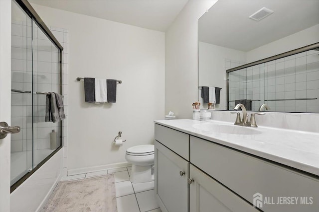full bath with tile patterned floors, toilet, visible vents, combined bath / shower with glass door, and vanity