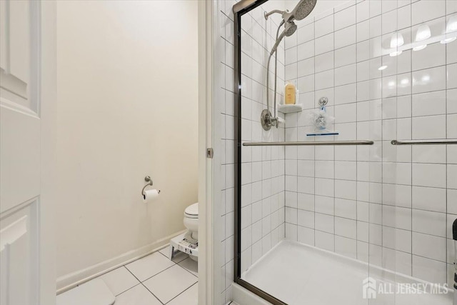 full bathroom featuring toilet, a shower stall, tile patterned flooring, and baseboards