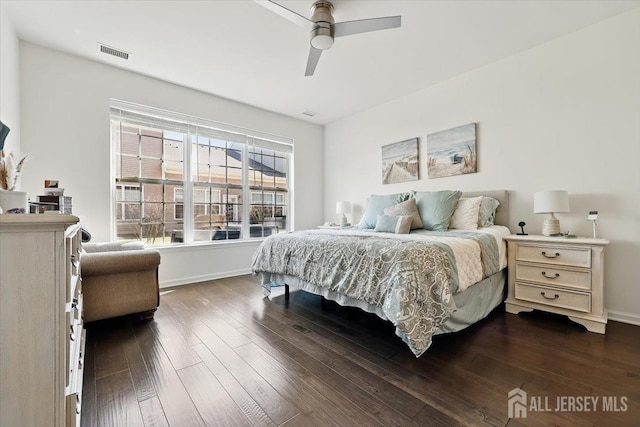bedroom featuring visible vents, a ceiling fan, baseboards, and dark wood-style floors