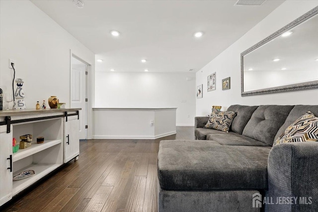living room with dark wood-style floors and recessed lighting