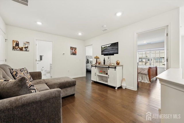 living area with baseboards, dark wood-style flooring, visible vents, and recessed lighting