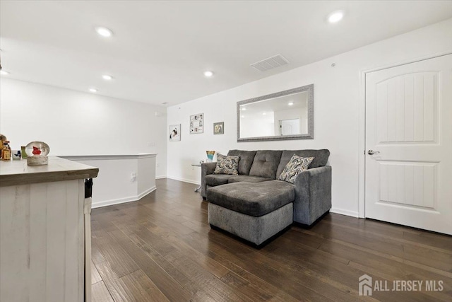 living area featuring visible vents, baseboards, recessed lighting, and dark wood-style floors