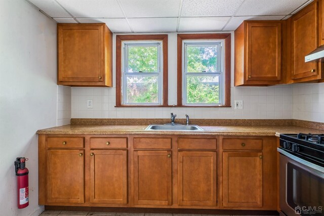 51 Delafield St, New Brunswick, NJ 08901 - kitchen with a sink, a drop ceiling, brown cabinets, tasteful backsplash, and stainless steel gas range oven
