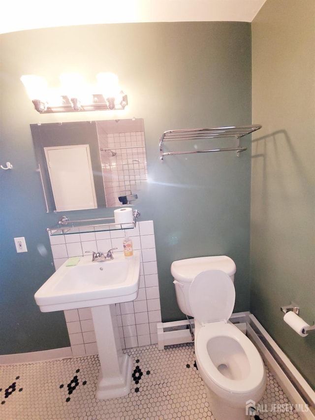 bathroom with tile patterned floors, a baseboard radiator, toilet, and tasteful backsplash