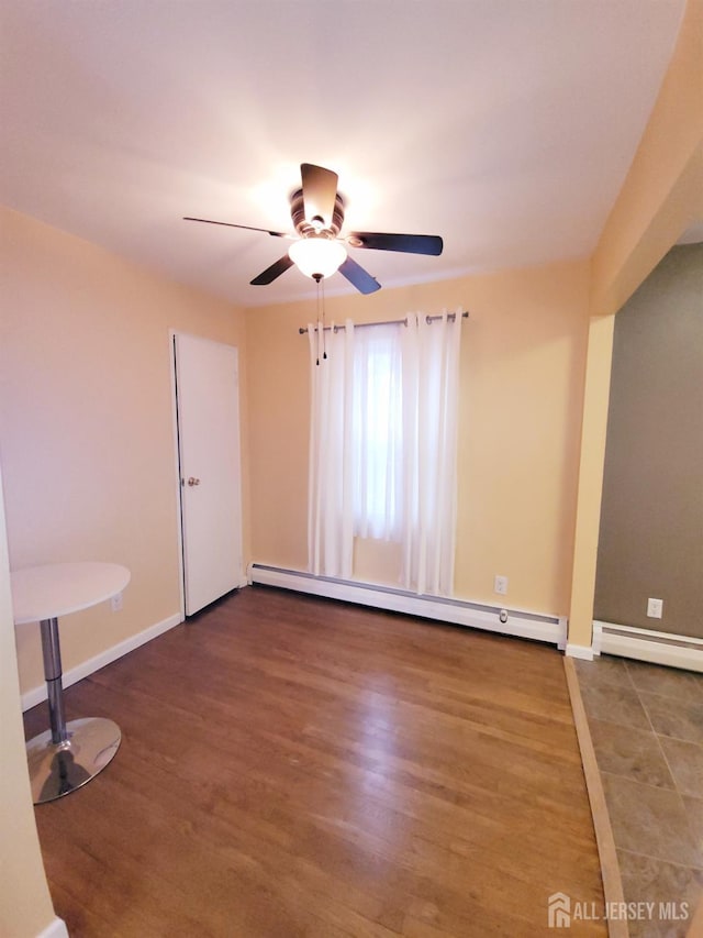 empty room with wood finished floors, baseboards, a baseboard radiator, ceiling fan, and baseboard heating