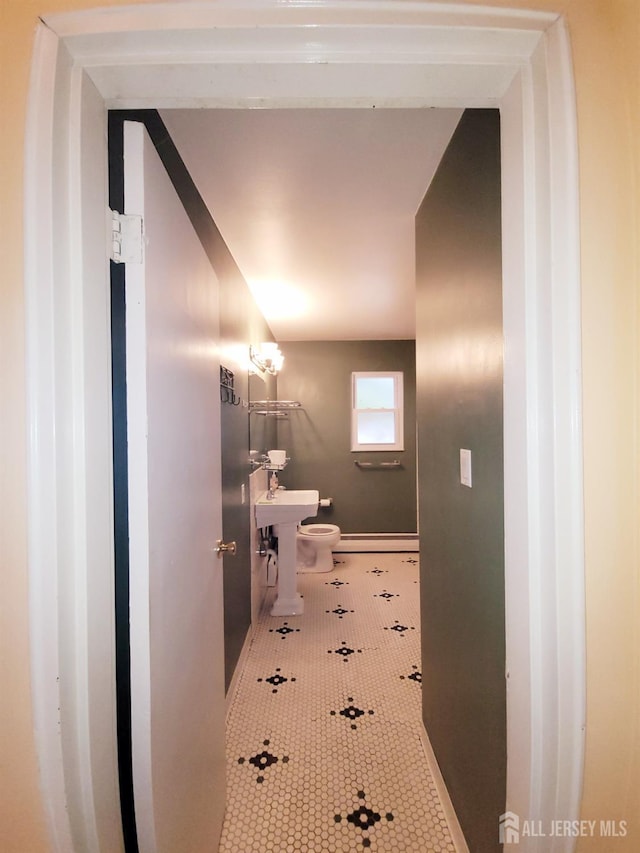 half bathroom with toilet and tile patterned flooring