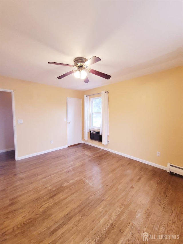 unfurnished room featuring baseboards and wood finished floors