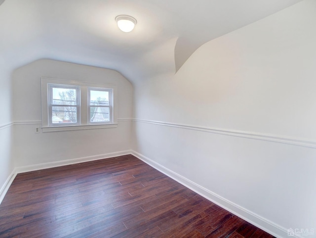 interior space featuring dark wood-type flooring and vaulted ceiling