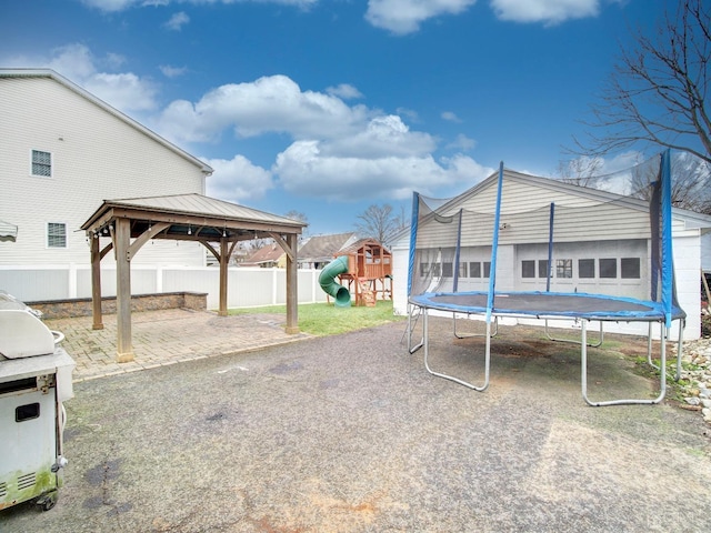 view of yard featuring a trampoline, a gazebo, a patio, and a playground