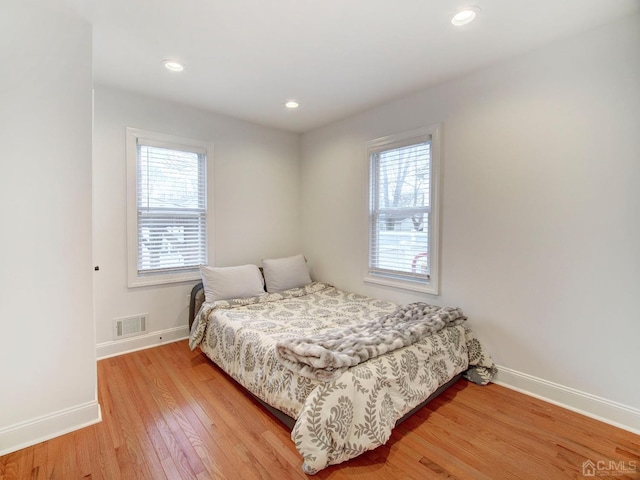 bedroom featuring light hardwood / wood-style floors and multiple windows