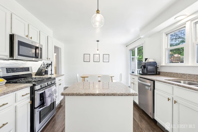 54 Morningside Rd, Colonia, NJ 07067 - kitchen with stainless steel appliances, a kitchen island, white cabinetry, dark wood-type flooring, and decorative light fixtures