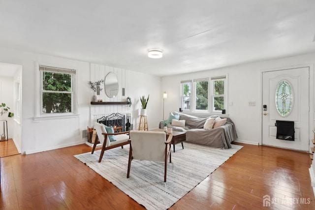 54 Morningside Rd, Colonia, NJ 07067 - living area featuring a warm lit fireplace, plenty of natural light, hardwood / wood-style floors, and baseboards