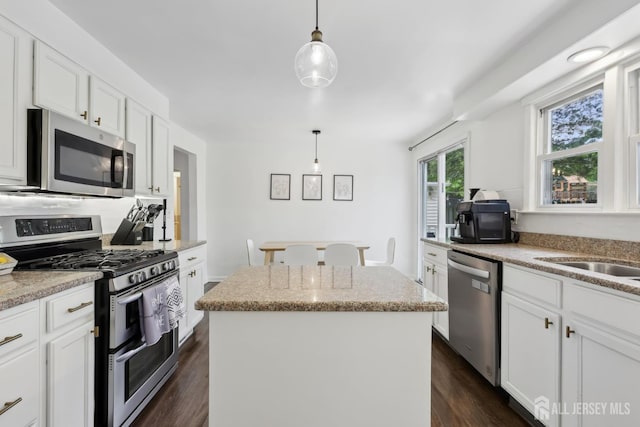 54 Morningside Rd, Colonia, NJ 07067 - kitchen with appliances with stainless steel finishes, a kitchen island, white cabinets, dark wood-style floors, and hanging light fixtures