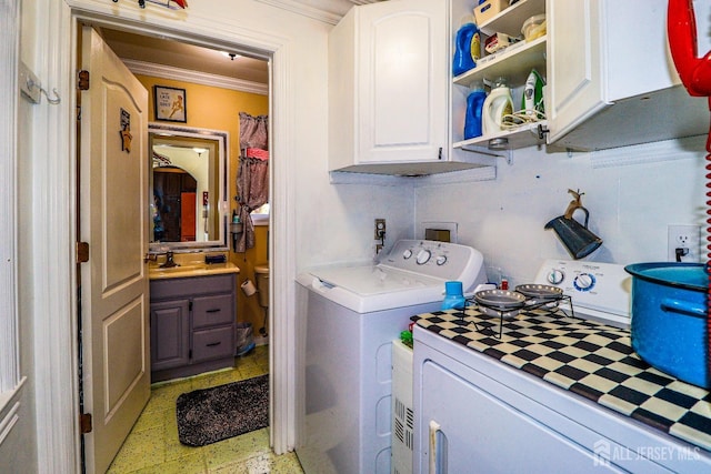 clothes washing area featuring cabinets, ornamental molding, washer and dryer, and sink