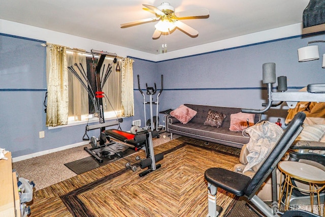 exercise area featuring baseboards, carpet, and a ceiling fan