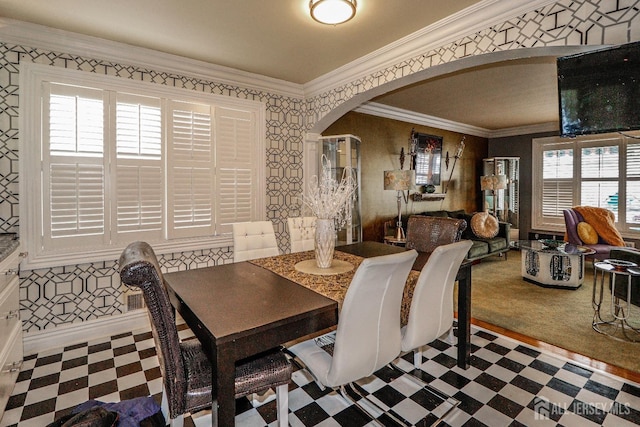 dining room with baseboards, wallpapered walls, arched walkways, crown molding, and tile patterned floors