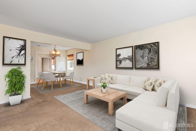 living area with an inviting chandelier, baseboards, and carpet flooring