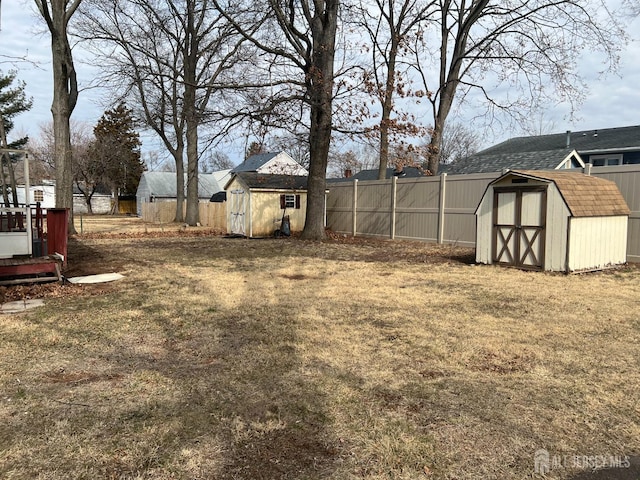 view of yard with an outbuilding, a fenced backyard, and a storage shed