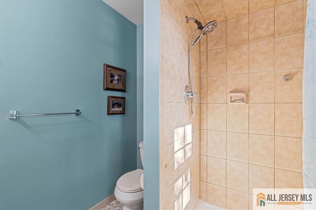 bathroom featuring toilet and tiled shower