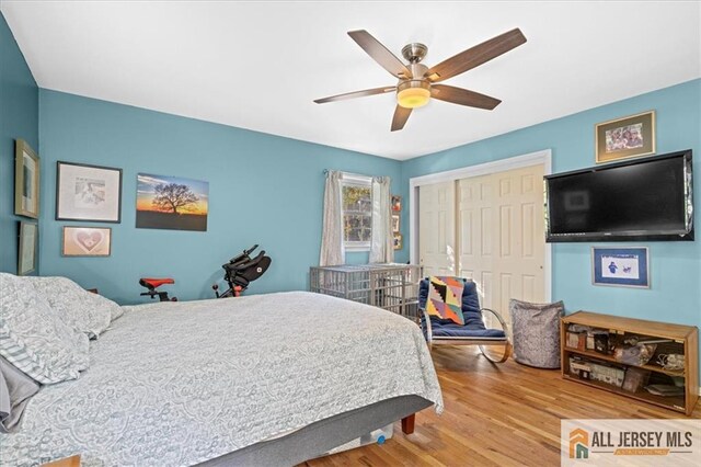 bedroom featuring wood-type flooring, a closet, and ceiling fan