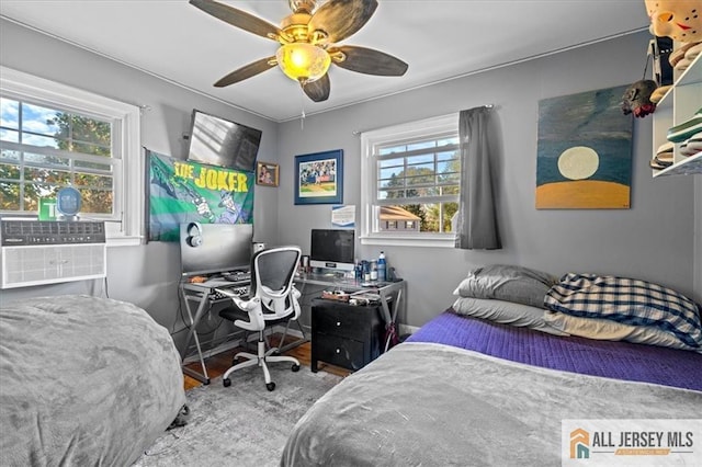 bedroom with ceiling fan and multiple windows