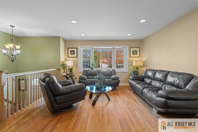 living room with light hardwood / wood-style floors and an inviting chandelier